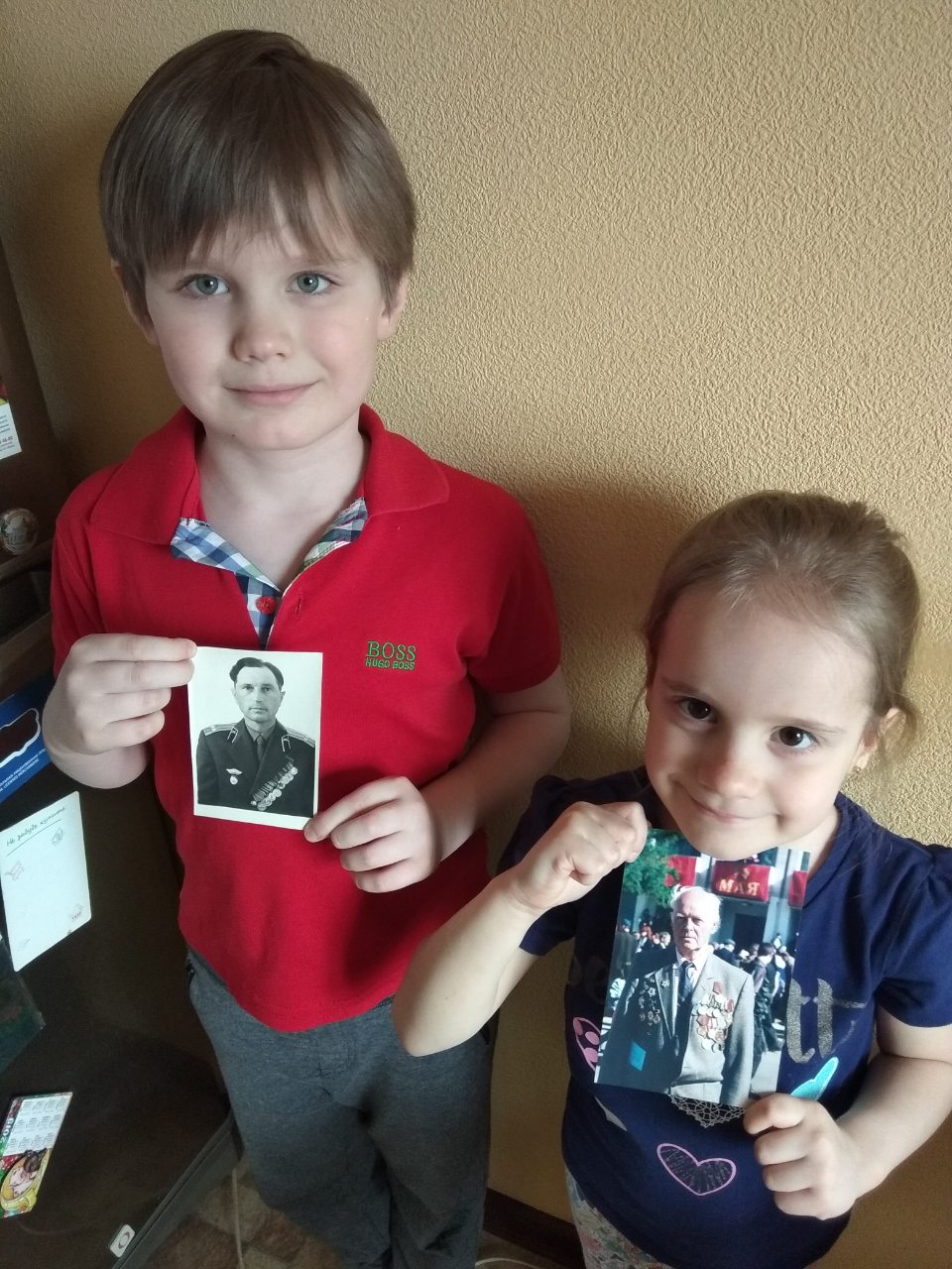 Мозговые Дима и Юлиана с портретами прадедушек